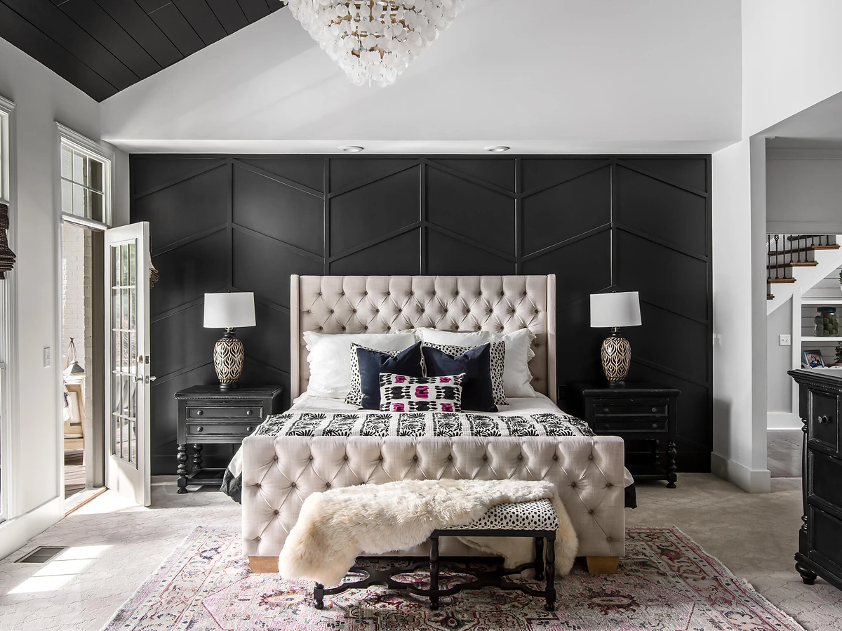 Primary bedroom with a charcoal panelled accent wall and tufted headboard