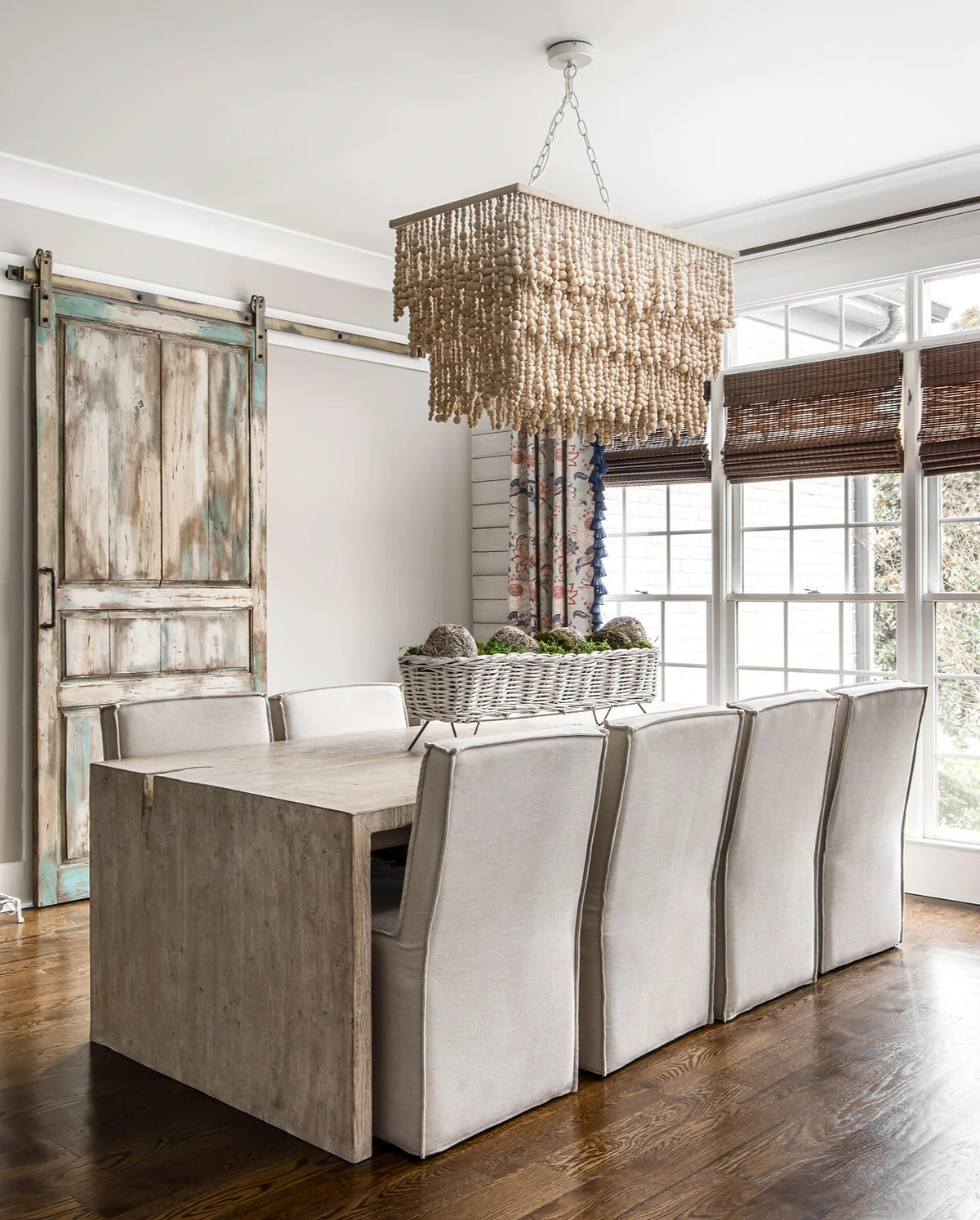Dining area with beaded chandelier and a reclaimed sliding barn door