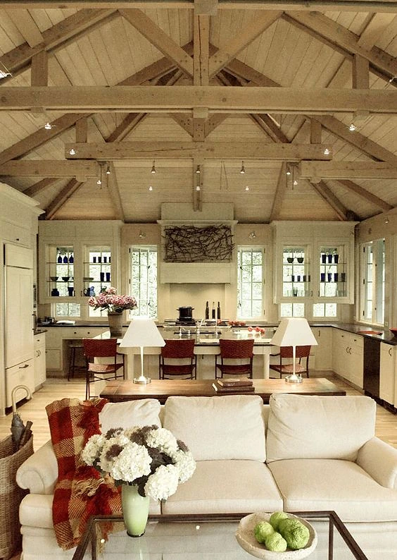 Open kitchen with vaulted wood-beamed ceiling and a marble island