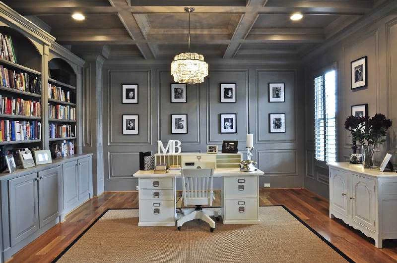 Home office with grey panelled walls, built-in bookcases and a gallery wall